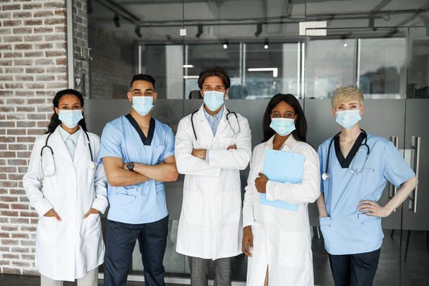Międzynarodowy zespół medyczny w maskach twarzy mający budowanie zespołu - Zdjęcie, obraz