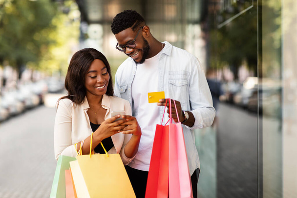 Ritratto di felice coppia afro con smartphone in possesso di carta di credito - Foto, immagini