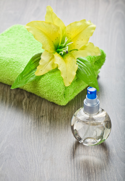 Yellow flower on towel and transparent bottle - Foto, afbeelding