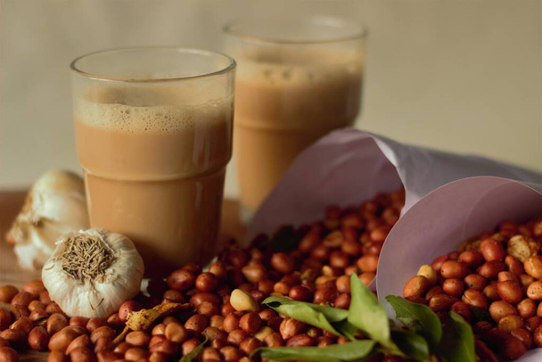 Indyjskie smażone orzeszki ziemne, aromatyzowane chili w proszku i asafetyda. Te chrupiące, chrupiące i pikantne indyjskie smażone orzeszki ziemne są idealne jako przekąska monsunowa. Ciesz się filiżanką chai lub kawy - Zdjęcie, obraz