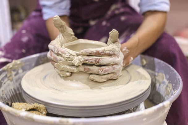 Artista de cerâmica fêmea molda o barro na roda de cerâmica. Artesanato artesanal criativo. Vista de perto. Estúdio de cerâmica. - Foto, Imagem
