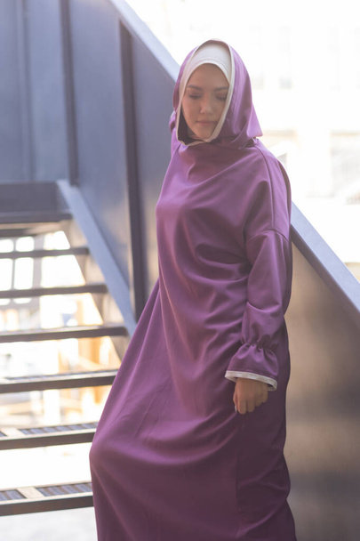 Islamic beautiful woman in a Muslim dress standing on a summer park street background forest autumn trees.world hijab day. - Фото, изображение