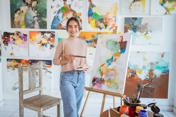 asian female artist painting on canvas doing some art projects on her studio workshop - 写真・画像