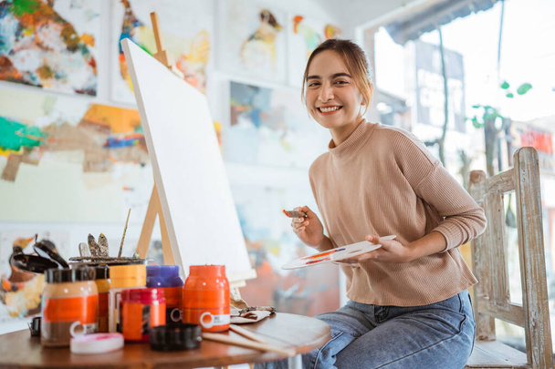 asian female painter painting on canvas in her workshop - Fotografie, Obrázek