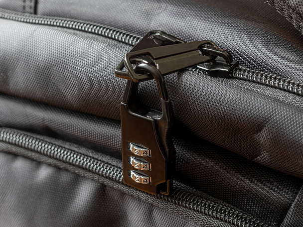 Cerradura de combinación de metal negro en una cremallera de plástico de una mochila negra - Foto, imagen