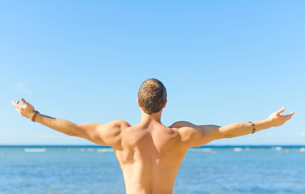 Muscular attractive man near the sea. Freedom concept. - Photo, image