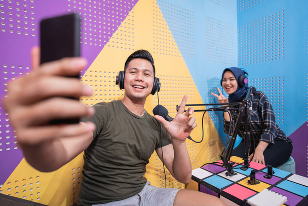 couple in podcast studio taking a selfie with their phone together - Foto, Bild