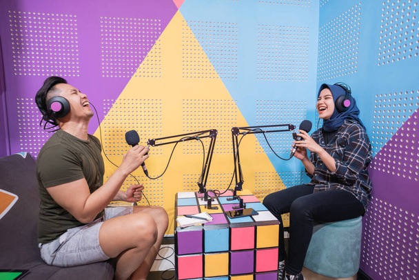 muslim asian woman and man talking on podcast studio together - Foto, Bild