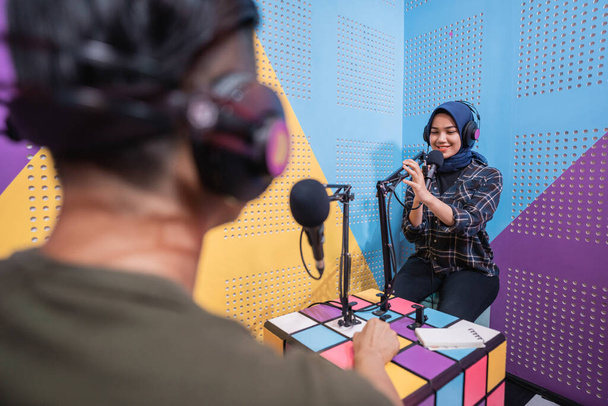 muslim woman recording podcast with a man in the studio - Valokuva, kuva