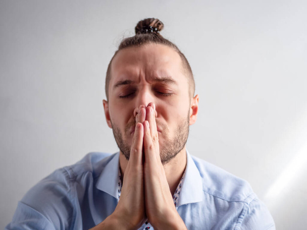 Bílý mladý hipster muž modlitby se zavřenýma očima - Fotografie, Obrázek