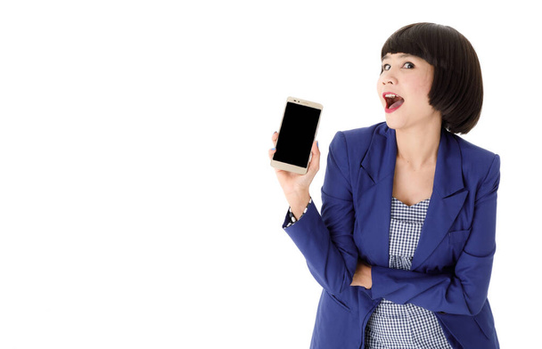 Lächelnde junge asiatische Geschäftsfrau im eleganten Outfit zeigt modernes Handy mit leerem schwarzen Bildschirm vor weißem Hintergrund - Foto, Bild