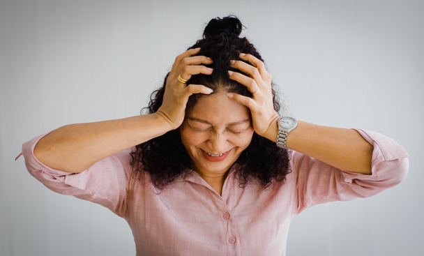 Азиатская женщина средних лет испытывает боль и страдает от внезапного инсульта и держит голову с страдающим лицом. Концепция проблемы мозга и головы - Фото, изображение