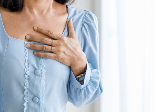 突然の心臓発作と胸を保持している認識できない女性。緊急時の医療の概念と鬱血性失敗または心肺蘇生、心臓の問題の影響. - 写真・画像