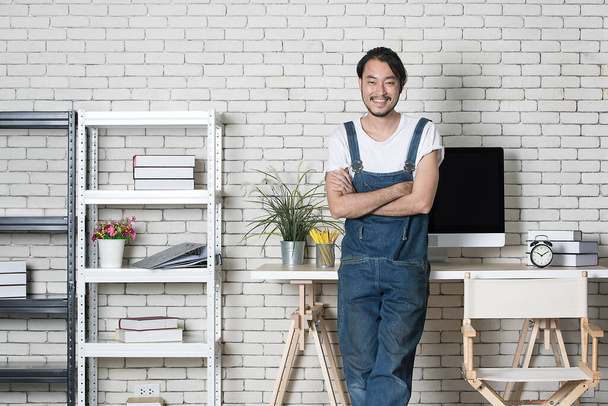 Joven barba hipster Hombre asiático de pie con feliz en su nueva oficina moderna de inicio mínimo, concepto para hombre de negocios feliz con la pequeña empresa de partida. - Foto, Imagen