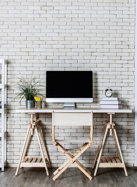 Minimalny styl z mniej dekoracji biurowych coner z metalową półką, krzesło dyrektora komputera i drewniany stół z cegły tle ściany. Pojęcie pracy w domu. - Zdjęcie, obraz