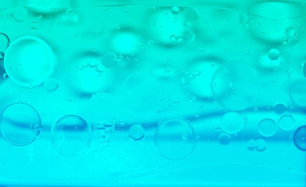 Blue glitter vintage lights background. Green texture background. Oil drops in water. - Photo, Image