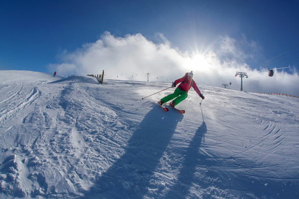 Skier skiing downhill in high mountains during sunny day - Photo, Image