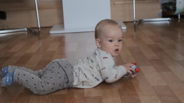 bambino impara a strisciare e gioca nella stanza sul pavimento - Filmati, video