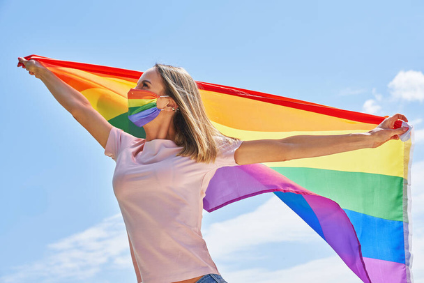 LGBTの旗を屋外で身に着けている. - 写真・画像