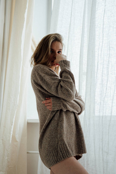 beautiful girl wearing warm sweater posing in light studio  - Fotografie, Obrázek