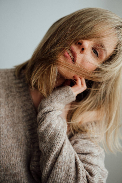 beautiful girl wearing warm sweater posing in light studio   - Photo, Image