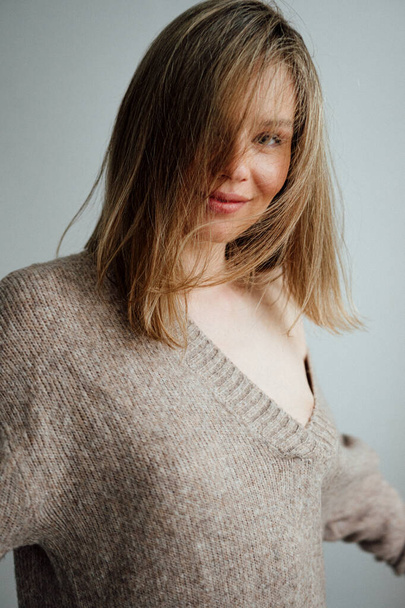 beautiful girl wearing warm sweater posing in light studio   - Foto, Bild