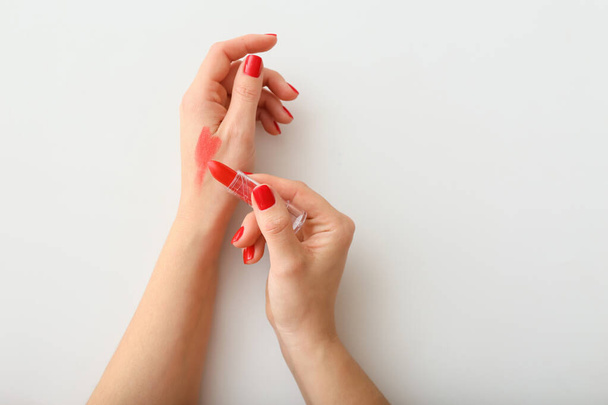 Female hands with beautiful manicure and lipstick on white background - Photo, Image