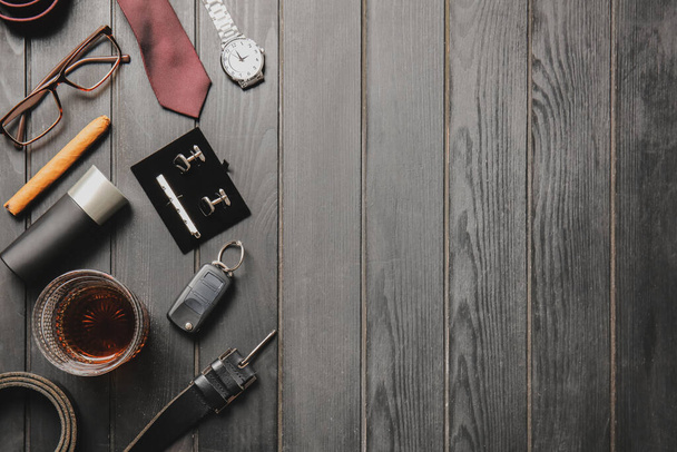 Stilvolle männliche Accessoires und ein Glas Whisky auf dunklem Holzhintergrund - Foto, Bild