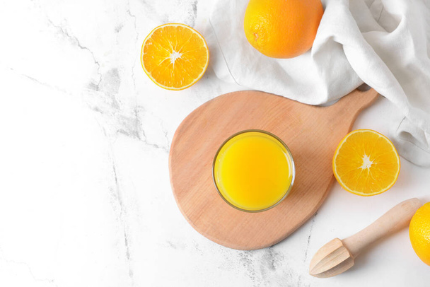 Γυαλί με νόστιμο χυμό πορτοκάλι σε ελαφρύ φόντο - Φωτογραφία, εικόνα
