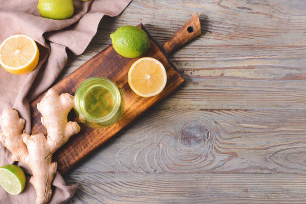 Glass of tasty drink with citrus fruits and ginger on wooden background - Photo, Image