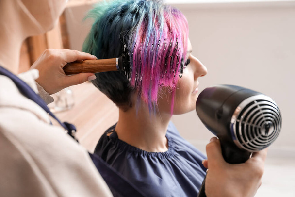 Kadın kuaför kuaför kuaförde güzel müşterinin saçlarını kurutuyor. - Fotoğraf, Görsel