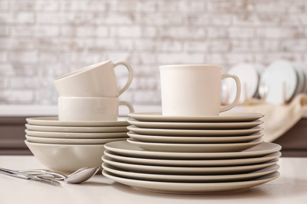 Set di piatti puliti sul tavolo in cucina
 - Foto, immagini