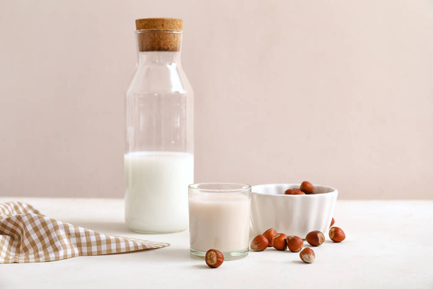 Ein Glas leckere Haselnussmilch und Zutaten auf dem Küchentisch - Foto, Bild