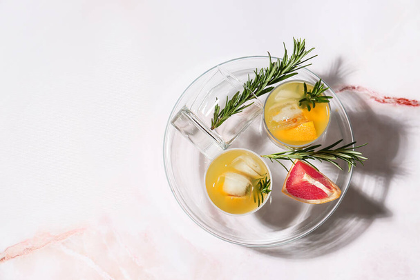 Glasses of tasty grapefruit cocktail with rosemary on white background - Φωτογραφία, εικόνα