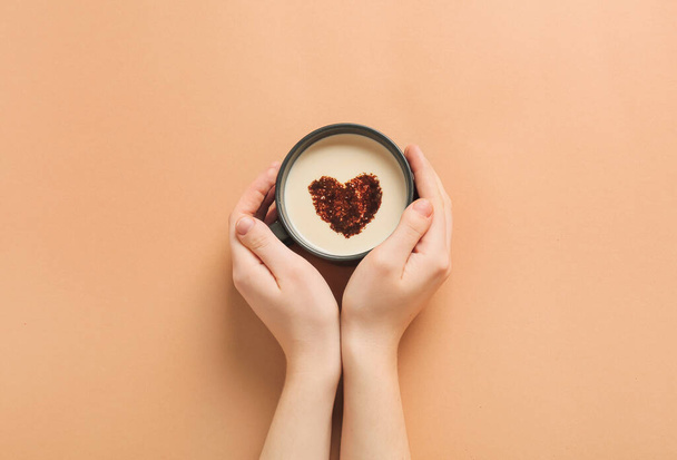 Female hands with cup of coffee on color background - Photo, Image