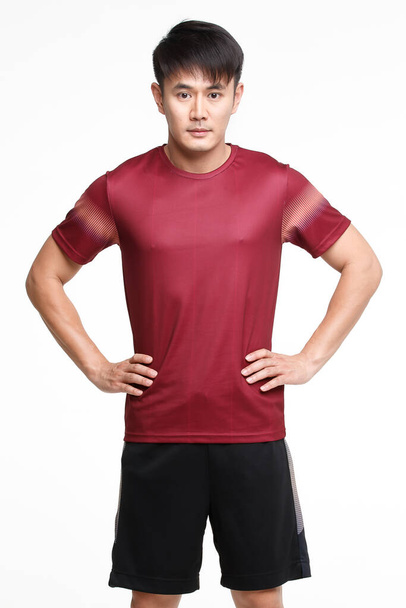 の画像の肖像画若いアジアのハンサムな強いスポーツマンで赤Tシャツ黒パンツとスポーツシューズで手スタンド足腰白の背景に隔離 - 写真・画像