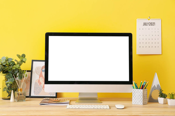 Σύγχρονη χώρο εργασίας με υπολογιστή και διακόσμηση κοντά στο χρώμα τοίχο - Φωτογραφία, εικόνα