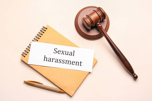 Notebook with text SEXUAL HARASSMENT and judge's gavel on light background - Zdjęcie, obraz