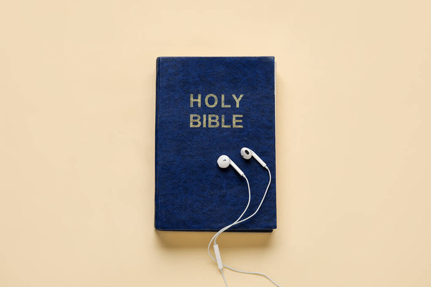 Santa Biblia y auriculares sobre fondo de color - Foto, imagen
