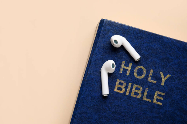 Święta Biblia i słuchawki na kolorowym tle, zbliżenie - Zdjęcie, obraz