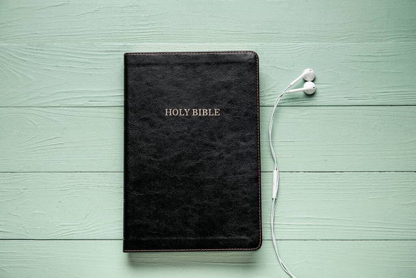 Santa Biblia y auriculares sobre fondo de madera de color - Foto, imagen