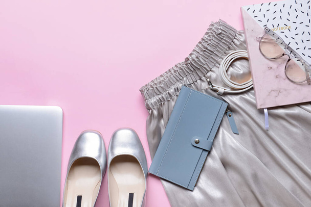 Stijlvolle vrouwelijke kleding en accessoires op roze achtergrond - Foto, afbeelding