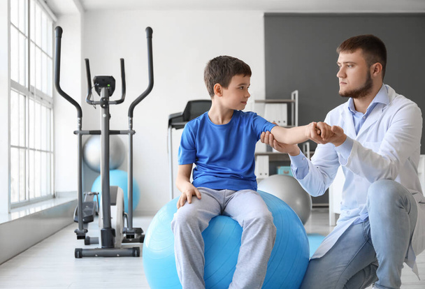Fisioterapeuta trabajando con un niño en un centro de rehabilitación - Foto, Imagen