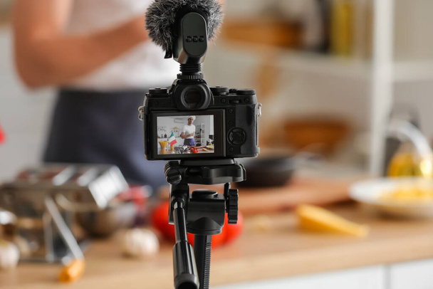 Bonito chef italiano com panela em exibição de câmera fotográfica na cozinha - Foto, Imagem