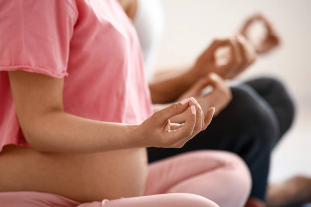 Jonge zwangere vrouw beoefent thuis yoga - Foto, afbeelding