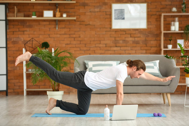 Молодий чоловік практикує йогу вдома
 - Фото, зображення