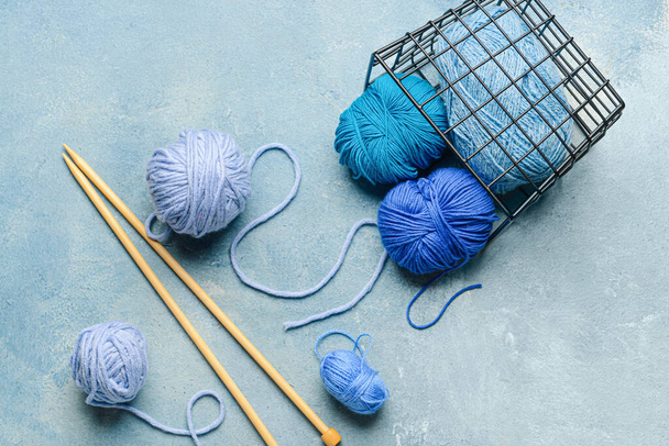 Basket with knitting yarn and needles on blue background - Fotografie, Obrázek
