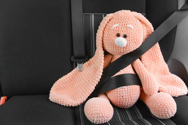 juguete sujetado conejito sentado en el coche - Foto, Imagen