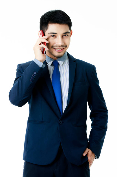 Portret skupionego młodego azjatyckiego biznesmena rozmawiającego przez telefon na odizolowanym białym tle. Studio shot, koncepcja komunikacji biznesowej - Zdjęcie, obraz