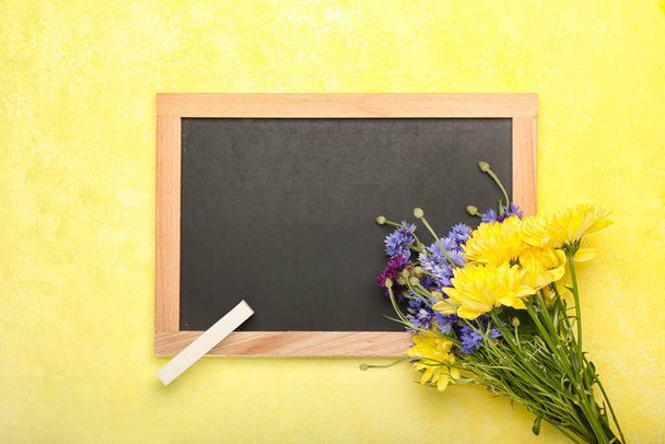 Boş karatahta, bir buket güzel çiçek ve tebeşirle renklendirilmiş arka plan - Fotoğraf, Görsel